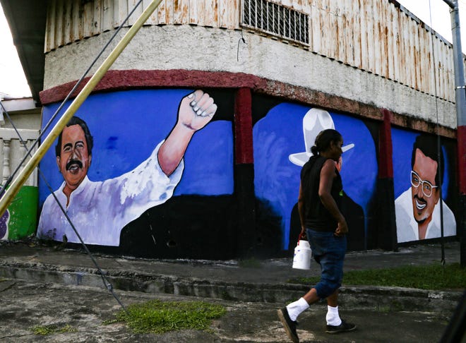 Una mujer pasa frente a un mural que representa a Daniel Ortega, presidente de Nicaragua, el 7 de noviembre de 2021 en Managua, Nicaragua. En los últimos meses han sido detenidos 39 miembros de la oposición, incluidos siete candidatos presidenciales. El Consejo Permanente de la OEA pidió elecciones justas y la liberación de los presos políticos. Daniel Ortega gobernó Nicaragua de 1979 a 1990 y volvió al poder en 2007. Ahora busca un cuarto mandato consecutivo en el poder mientras enfrenta acusaciones de autoritarismo creciente.