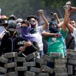 FILE - Protesters yell from behind the road block they erected as they face off with security forces near the University Politecnica de Nicaragua, UPOLI, in Managua, Nicaragua, Saturday, April 21, 2018. Nicaragua's National Assembly, controlled by Pr