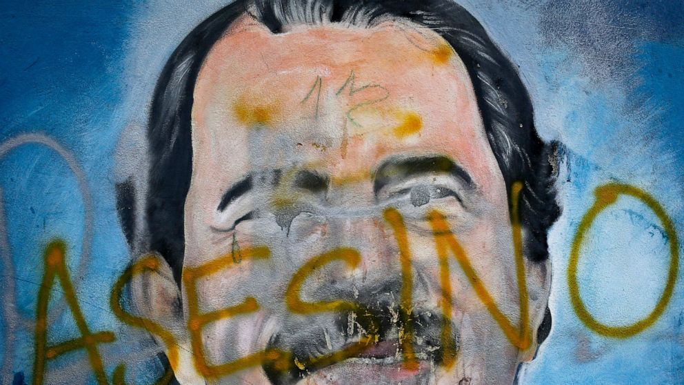 FILE - The Spanish word for "Murderer" covers a mural of Nicaragua's President Daniel Ortega, as part of anti-government protests demanding his resignation in Managua, Nicaragua, May 26, 2018. Four months before scheduled 2022 municipal elections, Ni