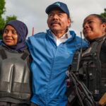 FILE - Nicaraguan police have their picture taken with President Daniel Ortega, in Masaya, Nicaragua, Friday, July 13, 2018. The government of the United States announced on Monday, June 13, 2022, that is restricting visas to members of the governmen