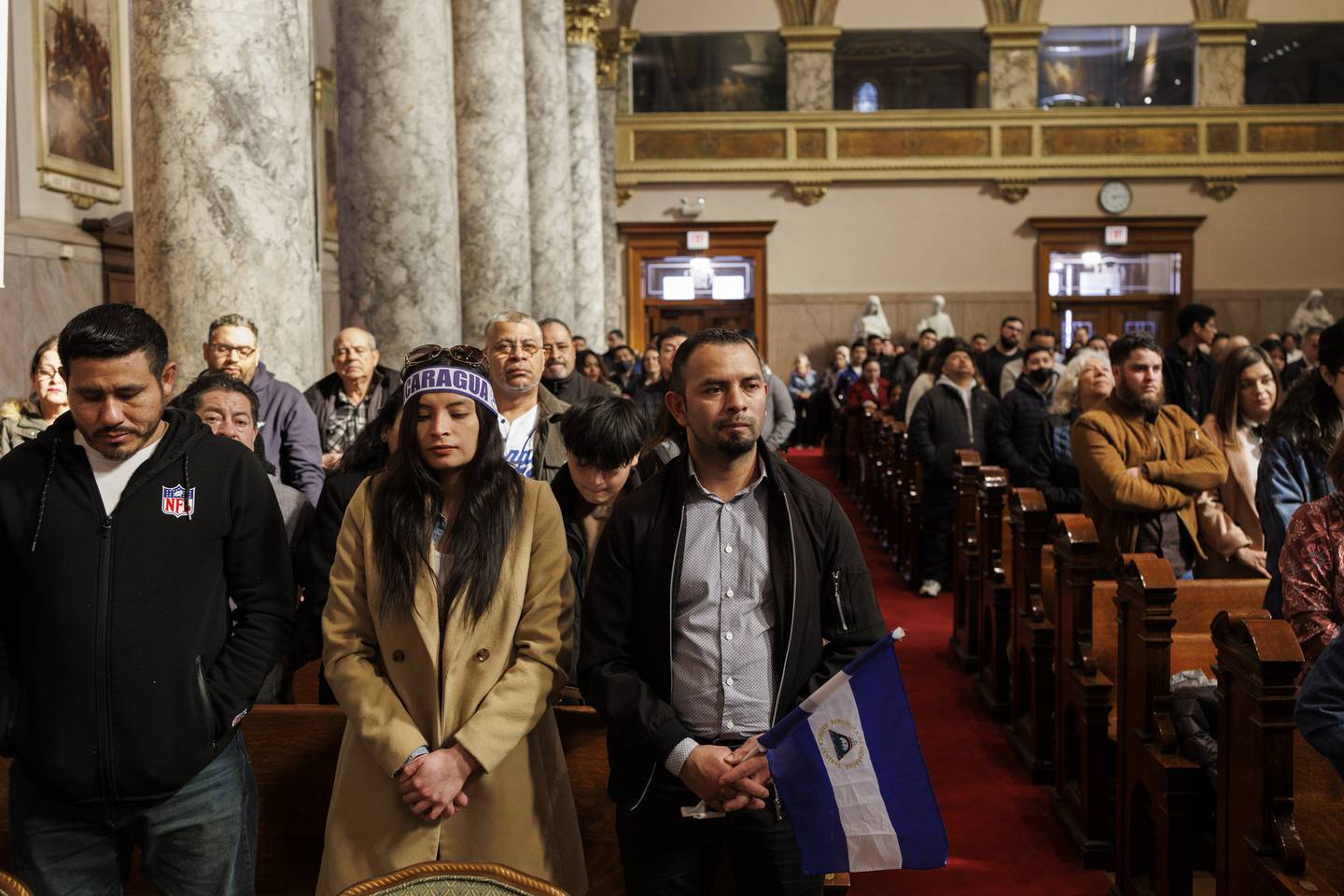 Los asistentes nicaragüenses se paran durante un servicio en St.  Iglesia Católica María del Lago el 2 de febrero.  19, 2023.