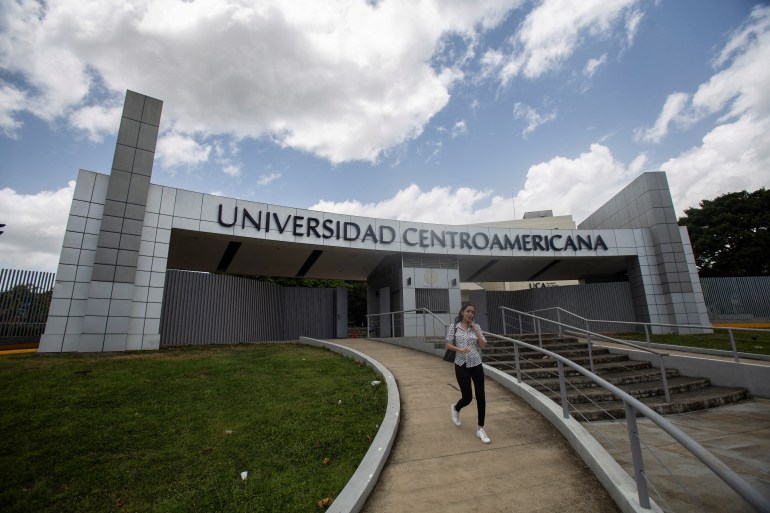 en 2023  16 de agosto  Una mujer sale de la Universidad Jesuita de Centroamérica (UCA) en Managua, Nicaragua.  Detrás está el camino de entrada con el nombre del colegio.