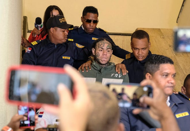 El rapero Daniel Hernández, conocido como Tekashi 6ix9ine, es escoltado por la policía cuando llega a la corte en el Palacio de Justicia en Santo Domingo, República Dominicana, el jueves de 2024. 25 de enero Las autoridades arrestaron al rapero en 2024. 17 de enero Violencia doméstica.