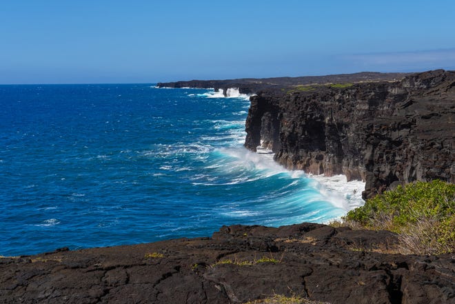 Las olas del Pacífico chocan contra el Arco del Mar de Holei y los escarpados acantilados de lava al final de Chain of Craters Road en el Parque Nacional de los Volcanes de Hawaii.
