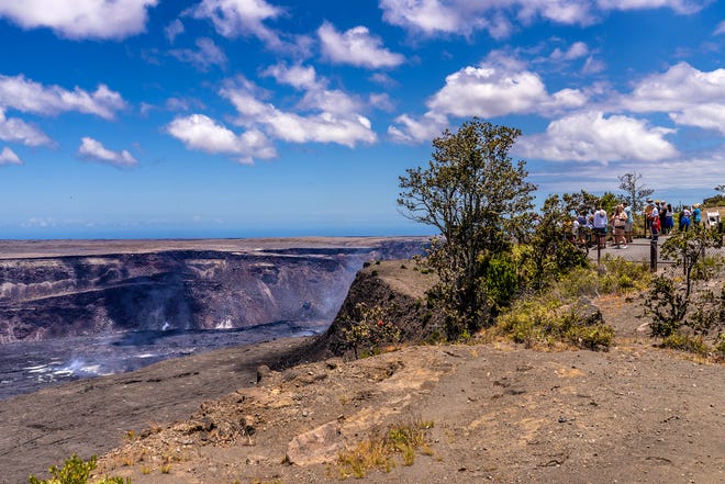 Los visitantes observan cómo se eleva el vapor y el gas desde el cráter Halema'uma'u en la cima del volcán Kilauea después de la erupción de 2023. en junio erupción.