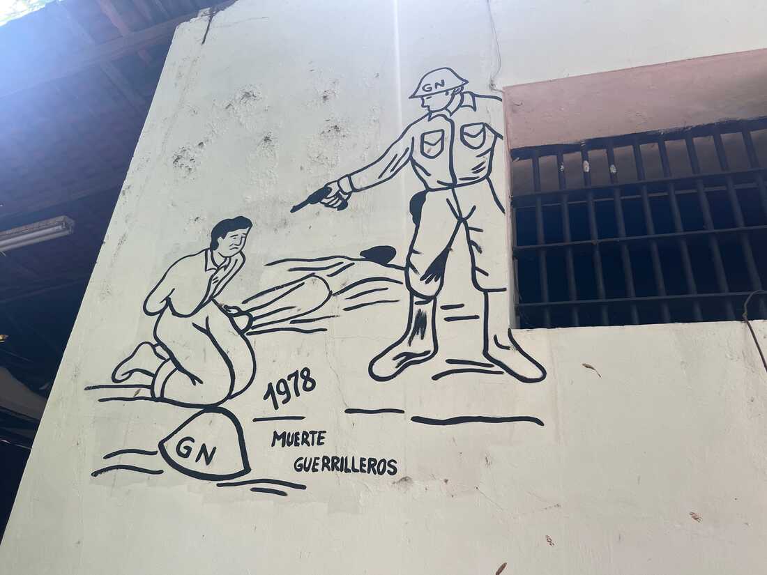 La pared muestra a un oficial de seguridad nacional preparándose para ejecutar a un partisano. 
