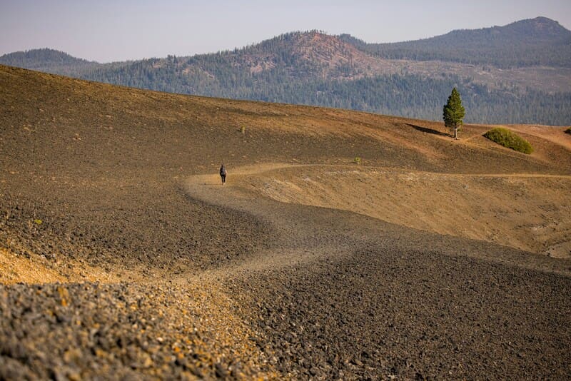 El hombre camina en un paisaje montañoso abandonado en el Parque Nacional Lassen.