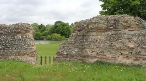 Ciudad de St. Albans y la hierba del consejo de distrito y el viejo muro de piedra, dice que hay ruinas romanas, Verulamium Park