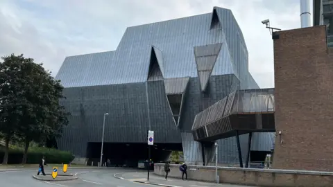 El lado del cuadrado de elefante es un gran edificio de metal gris que parece ser un elefante en algunos ángulos.