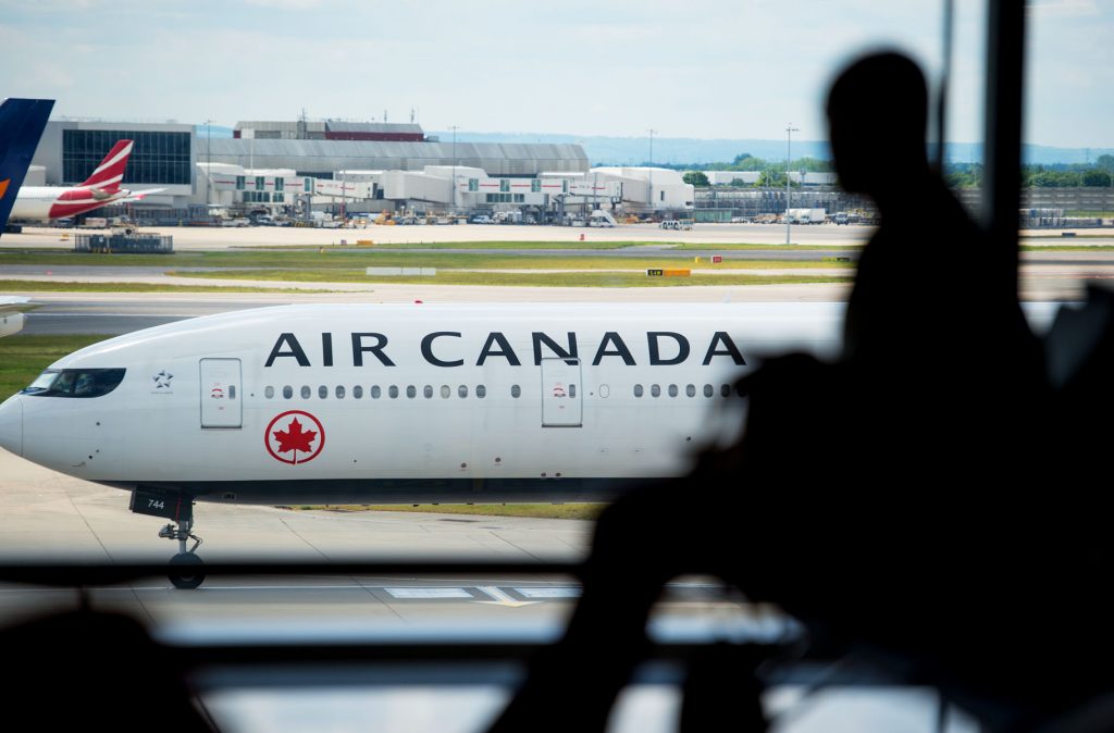 Un hombre sentado en una ventana mirando el avión