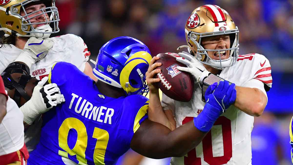 El extremo defensivo de los Rams de Los Ángeles Kobie Turner (91) sacks San Francisco 49ers Mac Jones (10) en tiempo extra en el estadio Sofi.