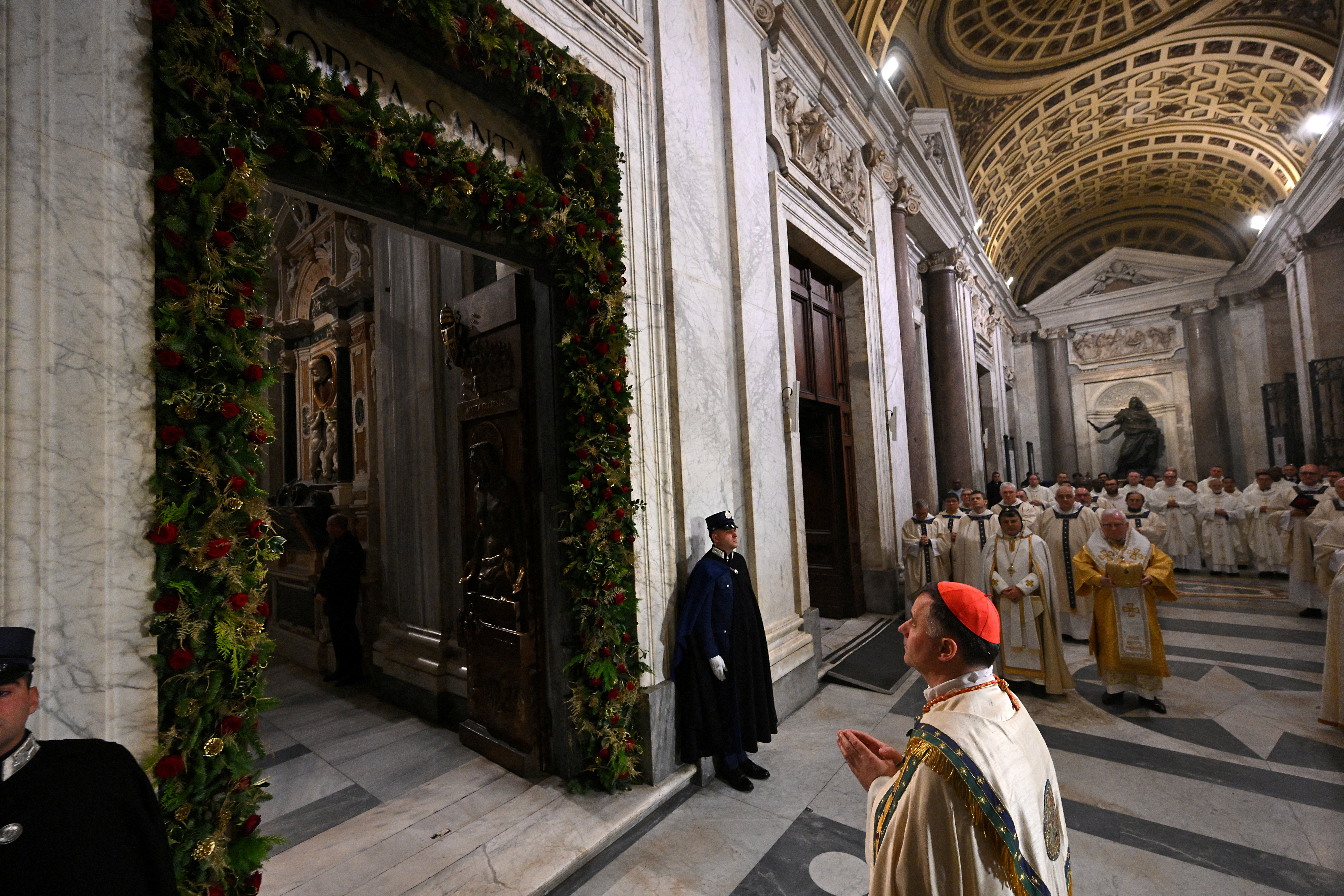 El cardenal Roland Makrick reza mientras se cierra la Puerta Santa en la Basílica Papal de Santa María la Mayor en Roma.