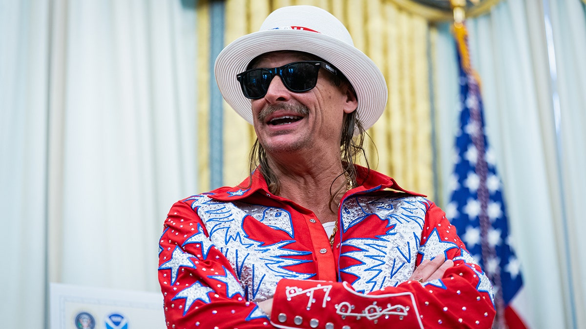Kid Rock sonríe a la Casa Blanca con gafas de sol oscuras y un sombrero blanco.