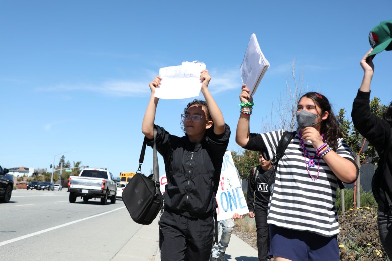 Los estudiantes muestran sus carteles a los transeúntes. Foto de Noé Magaña.