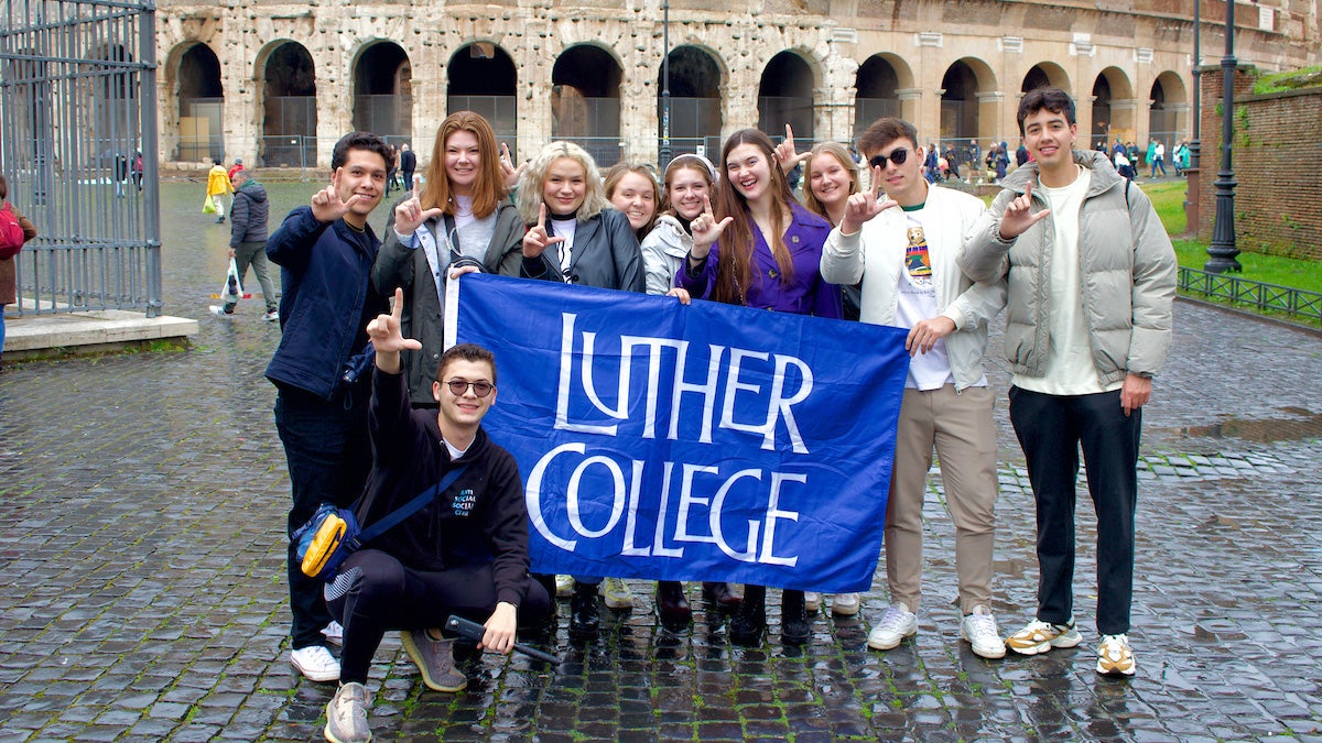 Los estudiantes del Luther College sostienen una bandera en Malta.