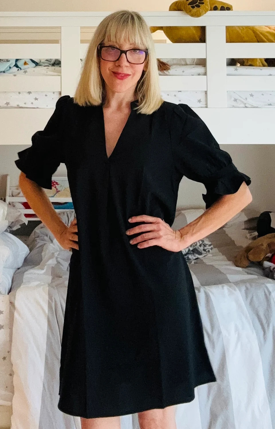 una mujer rubia con un vestido negro hasta la rodilla